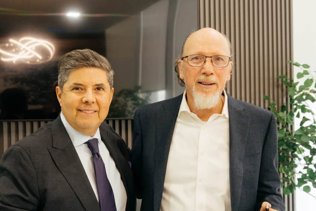 Two professional men in business attire at Renovo Health and Beauty, showcasing a partnership with Issels Treatment Center for advanced health solutions.