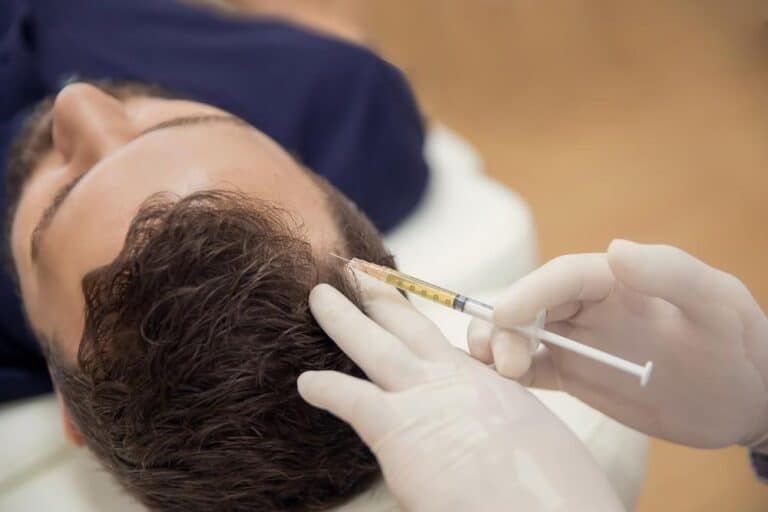 Patient receiving PRP hair treatment with a healthcare professional administering injections into the scalp.