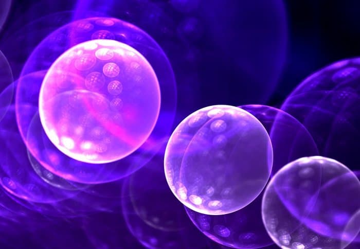 Close-up of glowing purple and blue cells or bubbles, highlighting cellular or biological themes.